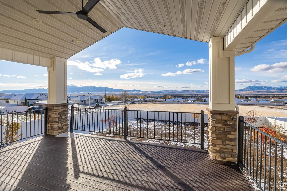 Wooden terrace featuring ceiling fan and a mountain view