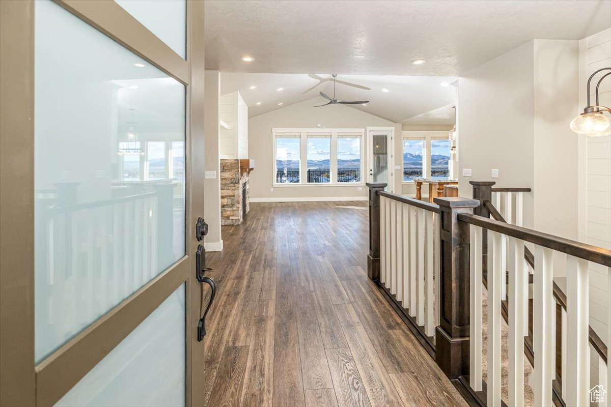 Hallway with dark hardwood / wood-style flooring and lofted ceiling