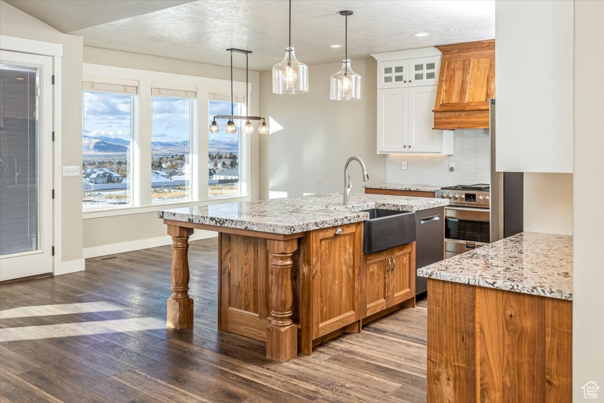 Kitchen featuring a kitchen island with sink, white cabinets, sink, dark hardwood / wood-style floors, and appliances with stainless steel finishes