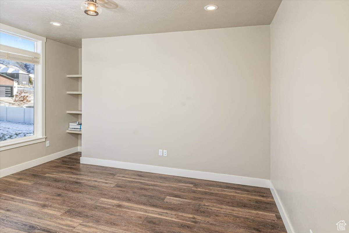 Empty room with dark hardwood / wood-style flooring