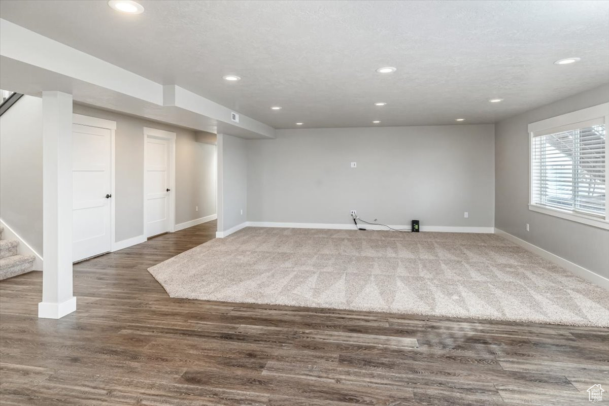 Basement with dark hardwood / wood-style flooring and a textured ceiling