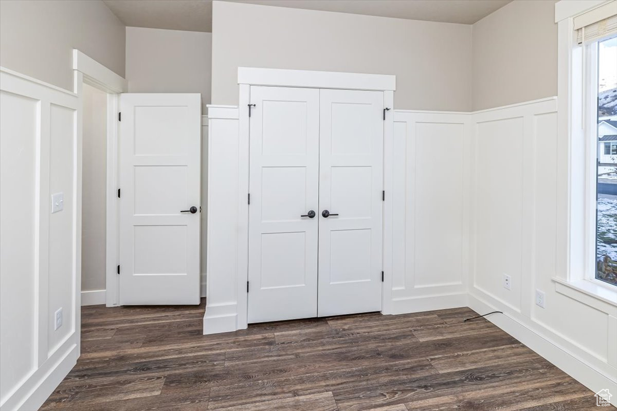 Unfurnished bedroom with a closet and dark hardwood / wood-style flooring