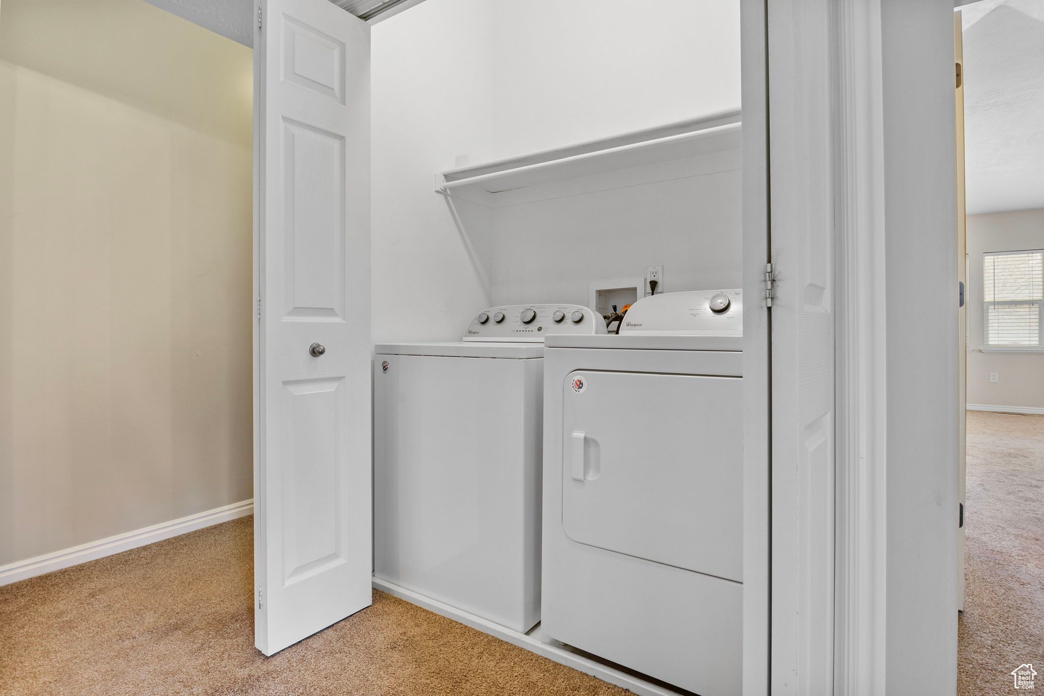 Washroom with light colored carpet and washer and clothes dryer