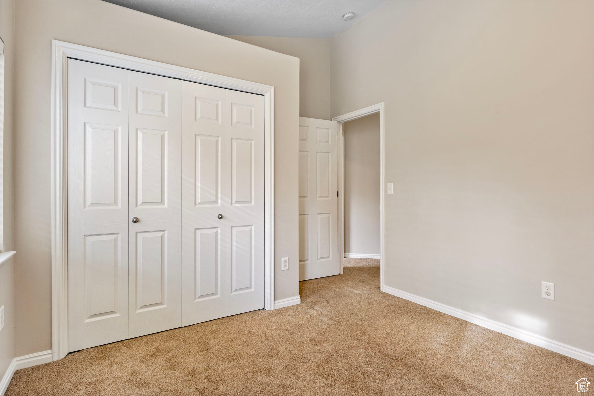 Unfurnished bedroom featuring light colored carpet and a closet