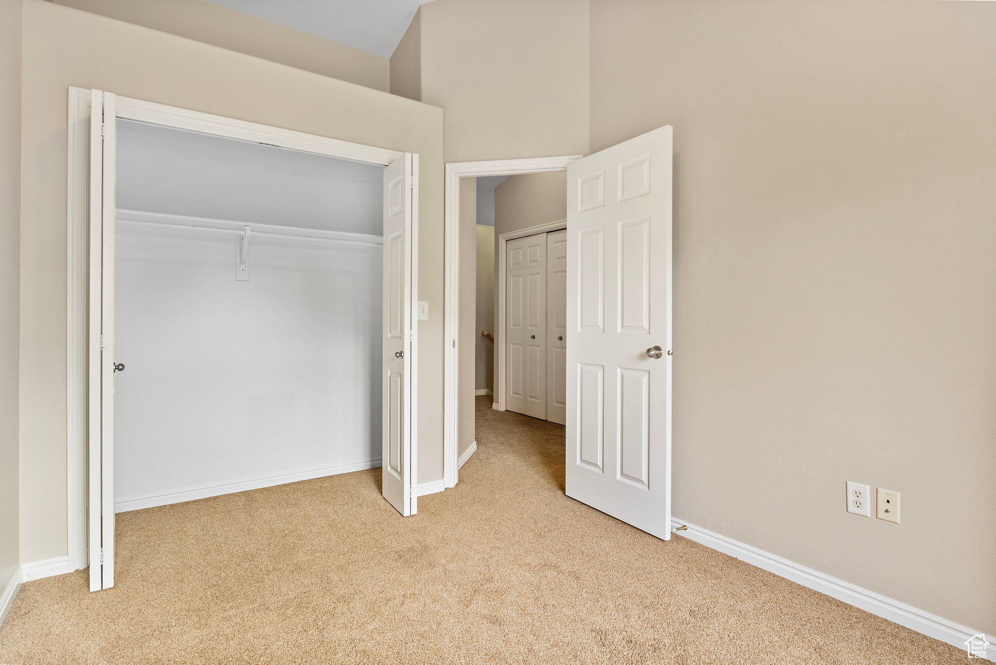 Unfurnished bedroom featuring light carpet and a closet