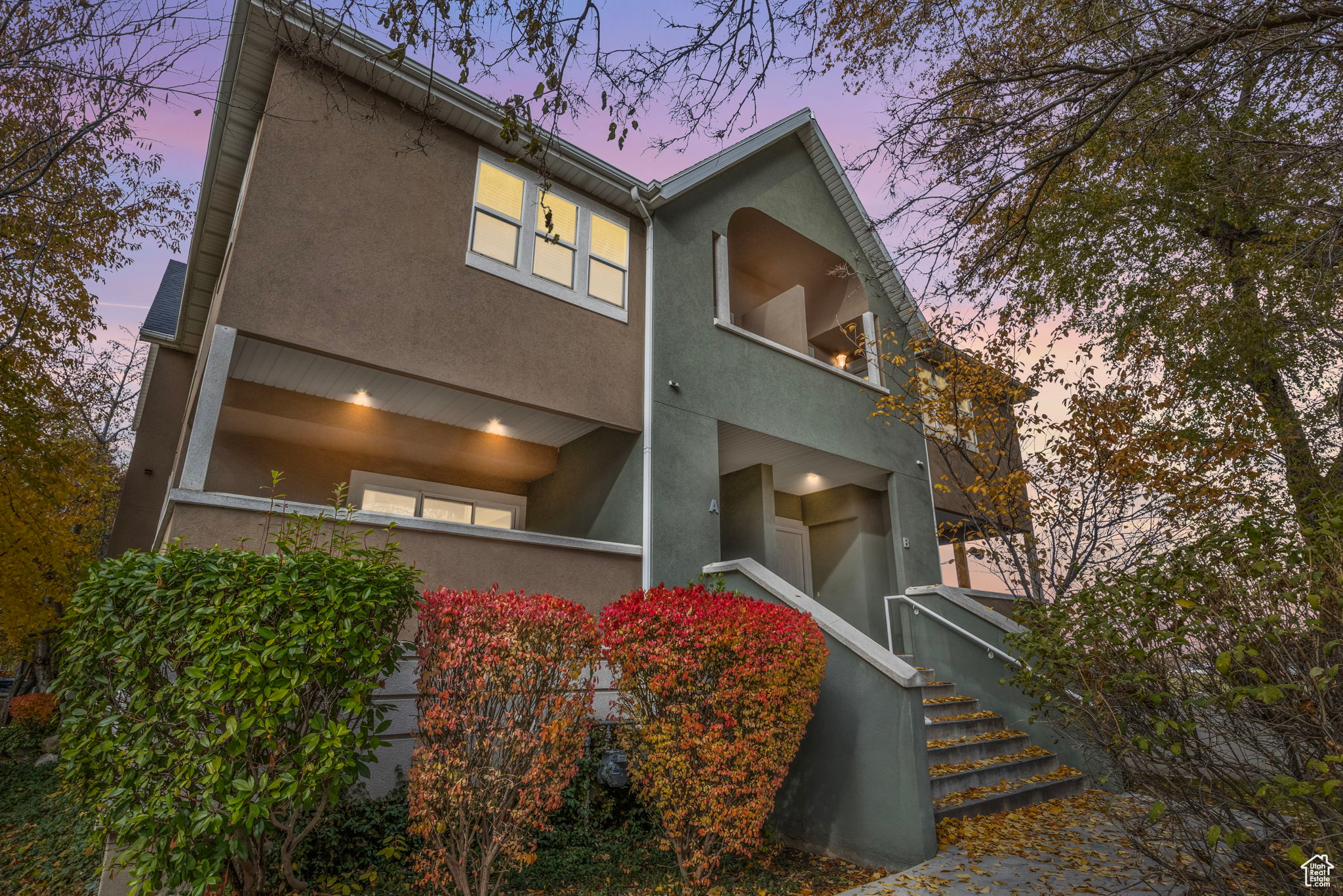 Back house at dusk featuring a balcony