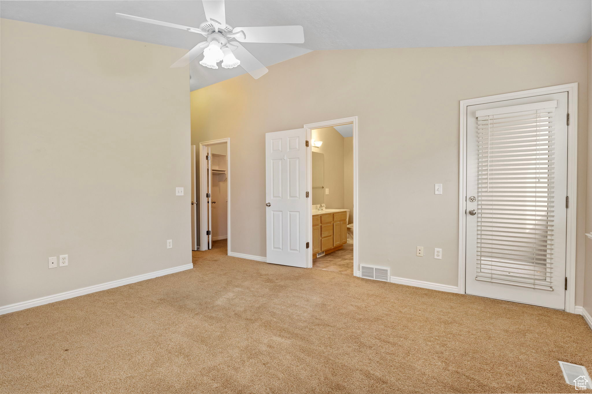 Unfurnished bedroom featuring ceiling fan, light colored carpet, and vaulted ceiling