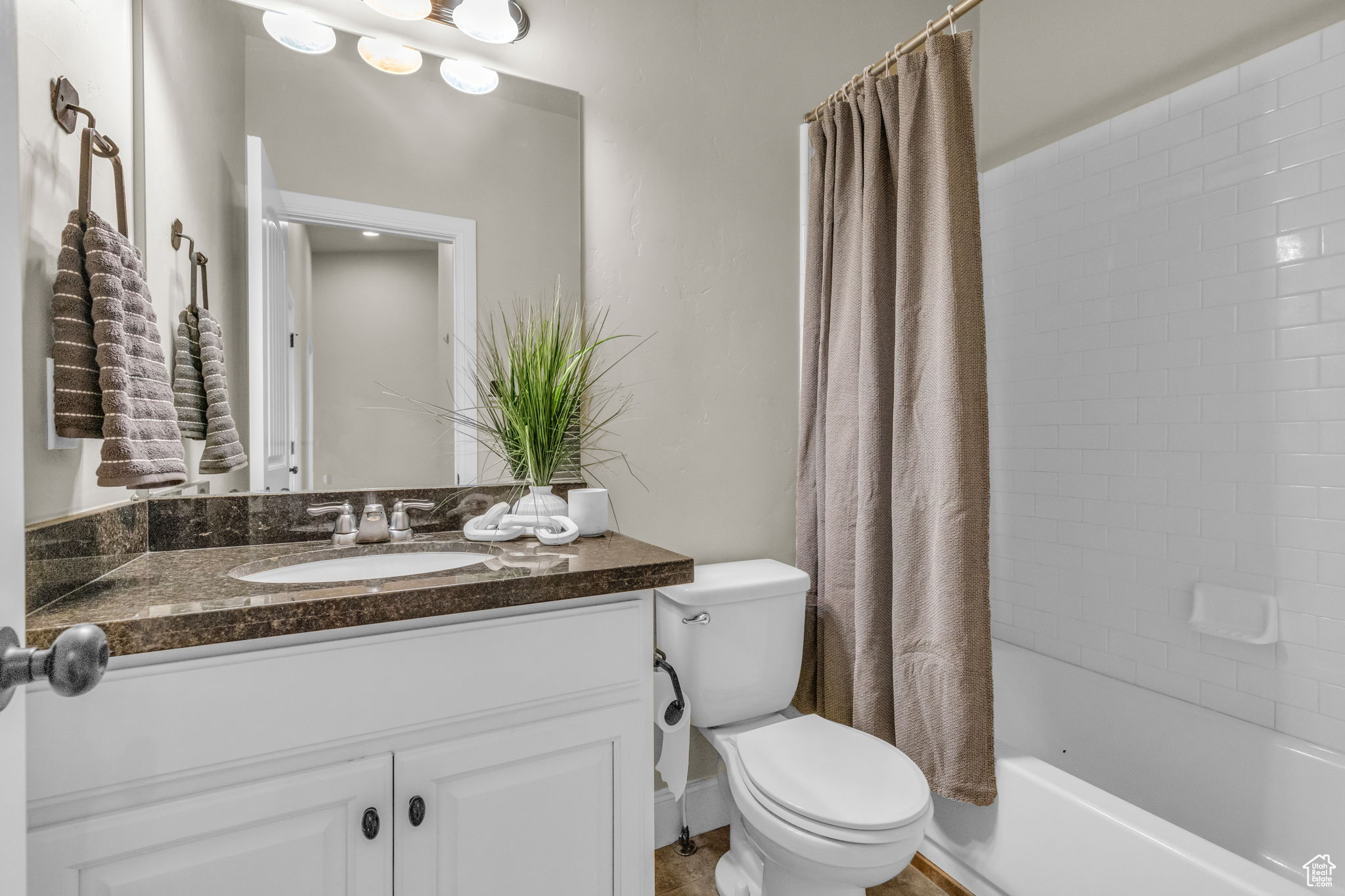 Full bathroom featuring shower / bath combo, vanity, and toilet