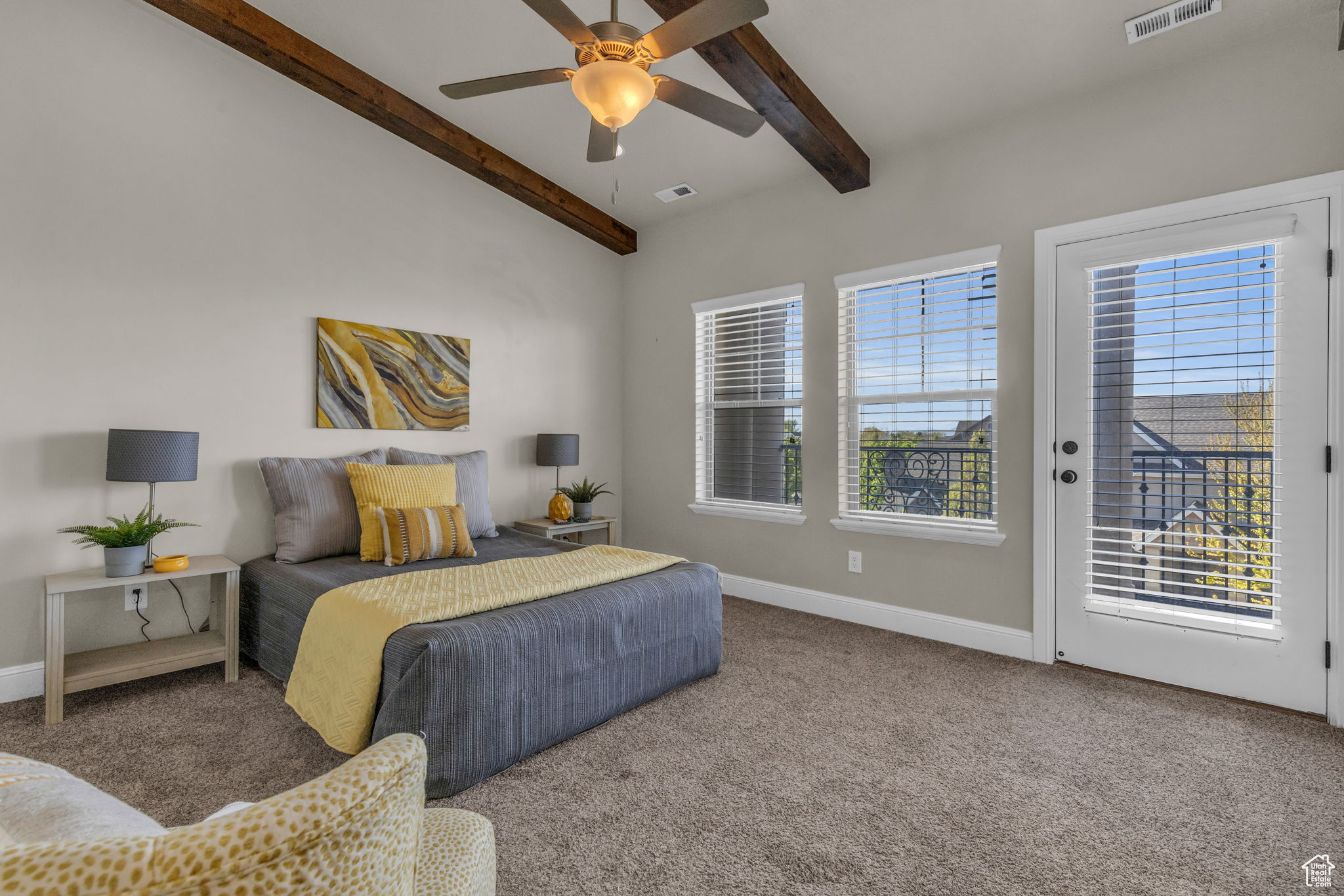 Carpeted bedroom with ceiling fan, lofted ceiling with beams, and access to exterior