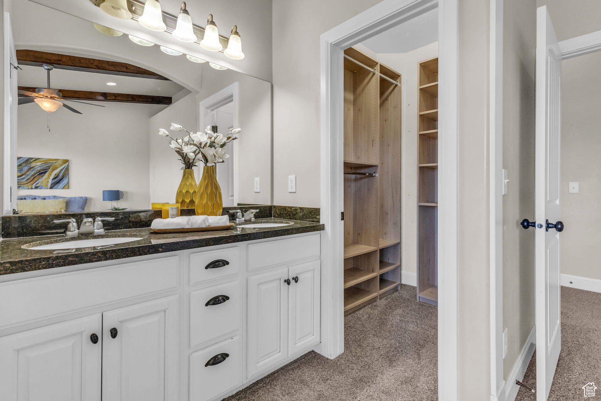 Bathroom featuring beam ceiling, ceiling fan, and vanity