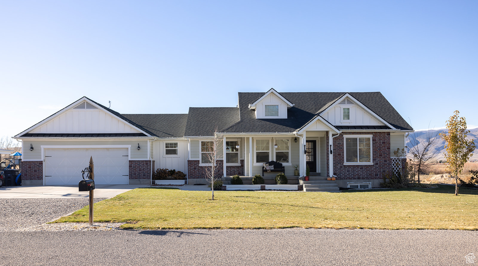 View of front of house with a porch, a garage, and a front lawn