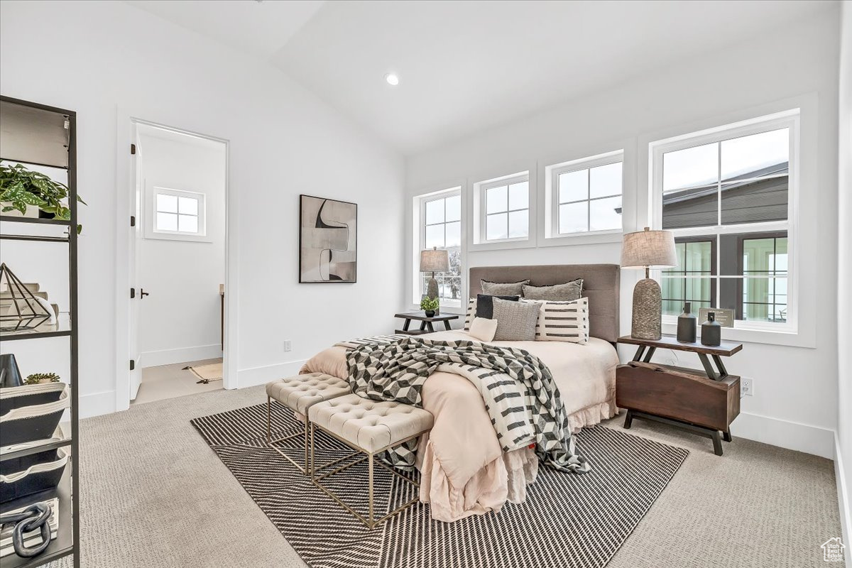 Carpeted bedroom with lofted ceiling