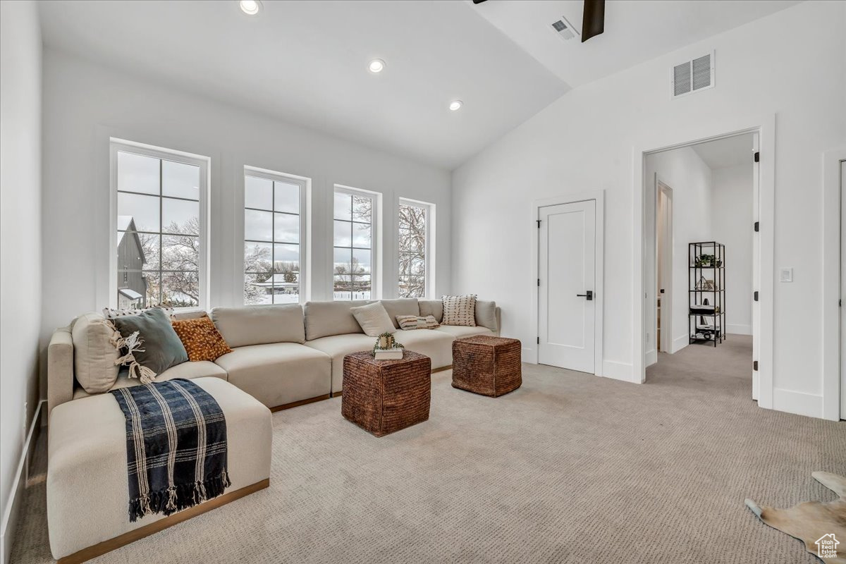 Living room with lofted ceiling and light carpet