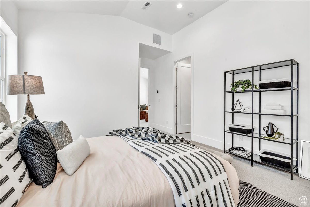 Bedroom with carpet and vaulted ceiling