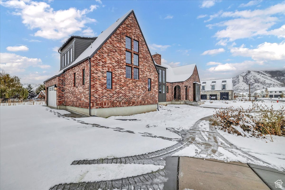 View of snow covered exterior with a garage