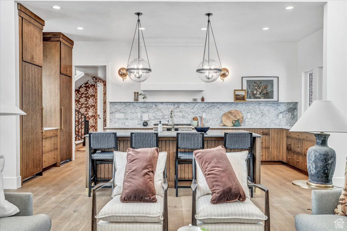 Living room with an inviting chandelier and light hardwood / wood-style flooring