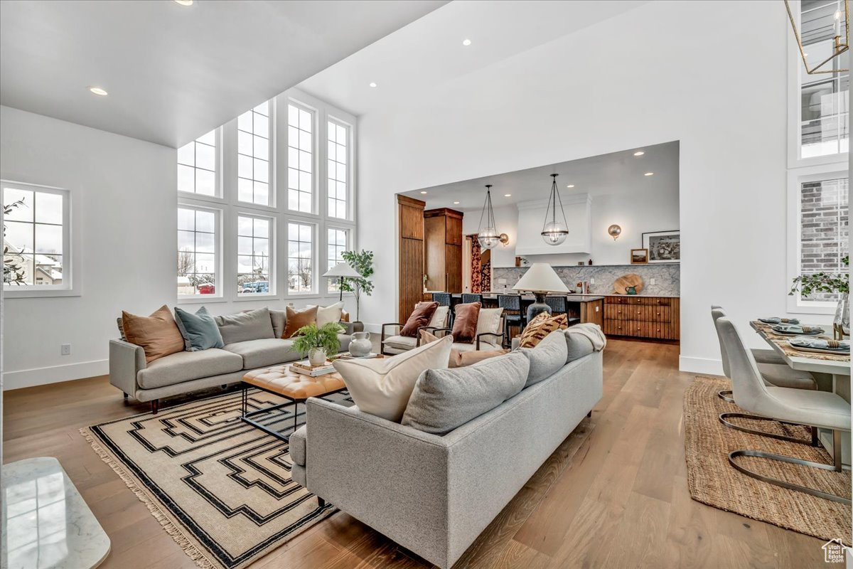 Living room with light hardwood / wood-style floors and a towering ceiling