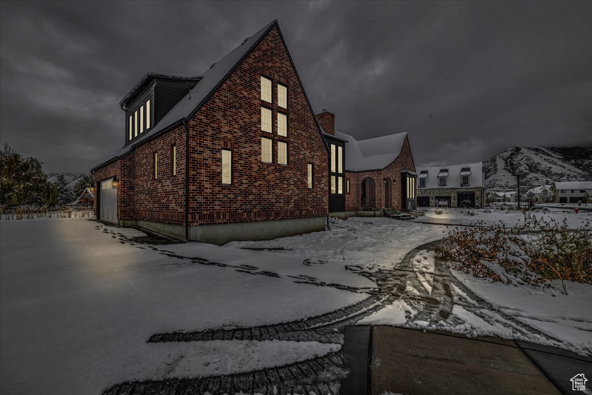 View of snowy exterior featuring a garage