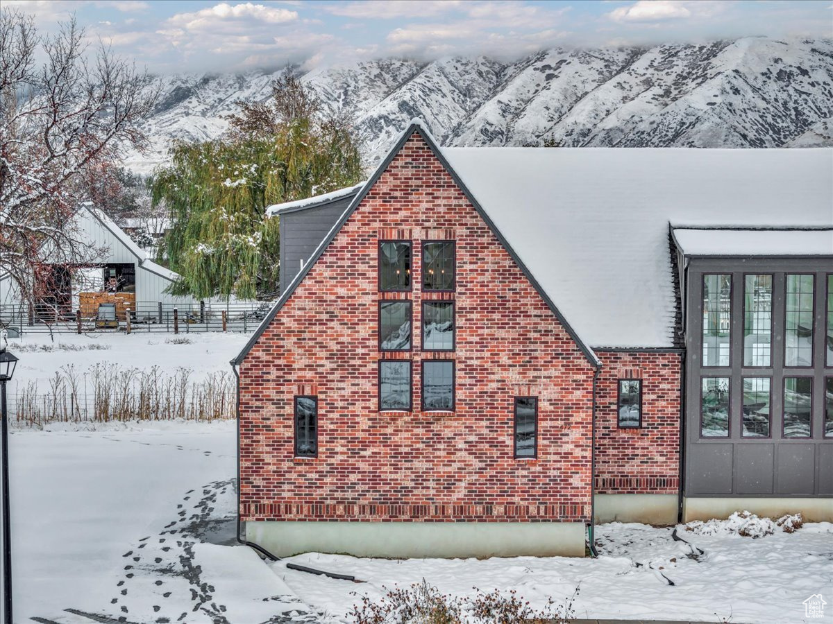 View of snow covered exterior featuring a mountain view