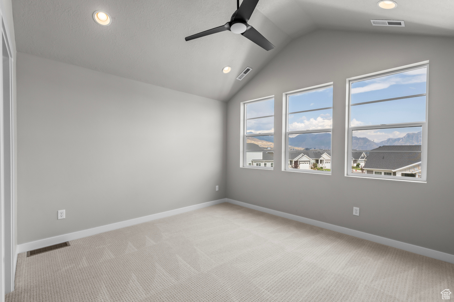 Unfurnished room with light carpet, ceiling fan, and lofted ceiling