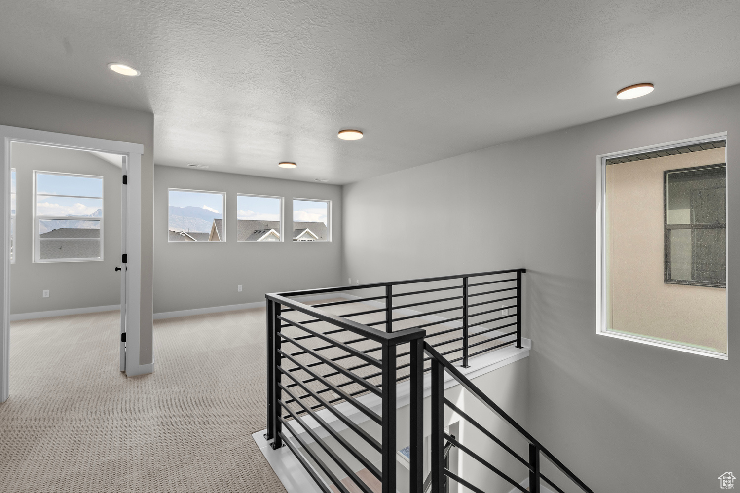 Hall with light carpet and a textured ceiling