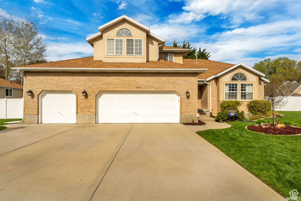 View of front property with a front lawn and a garage