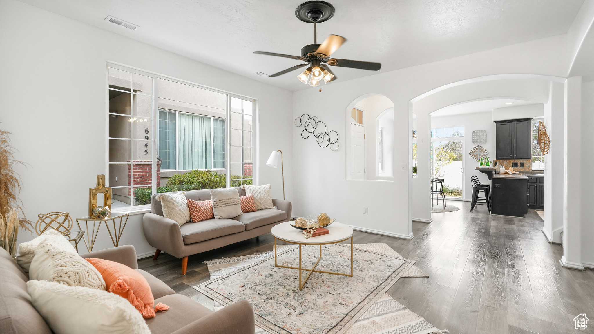 Living room featuring dark hardwood / wood-style flooring, ceiling fan, and plenty of natural light