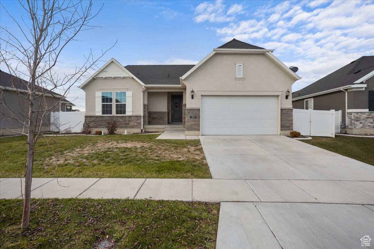 View of front facade featuring a front yard and a garage