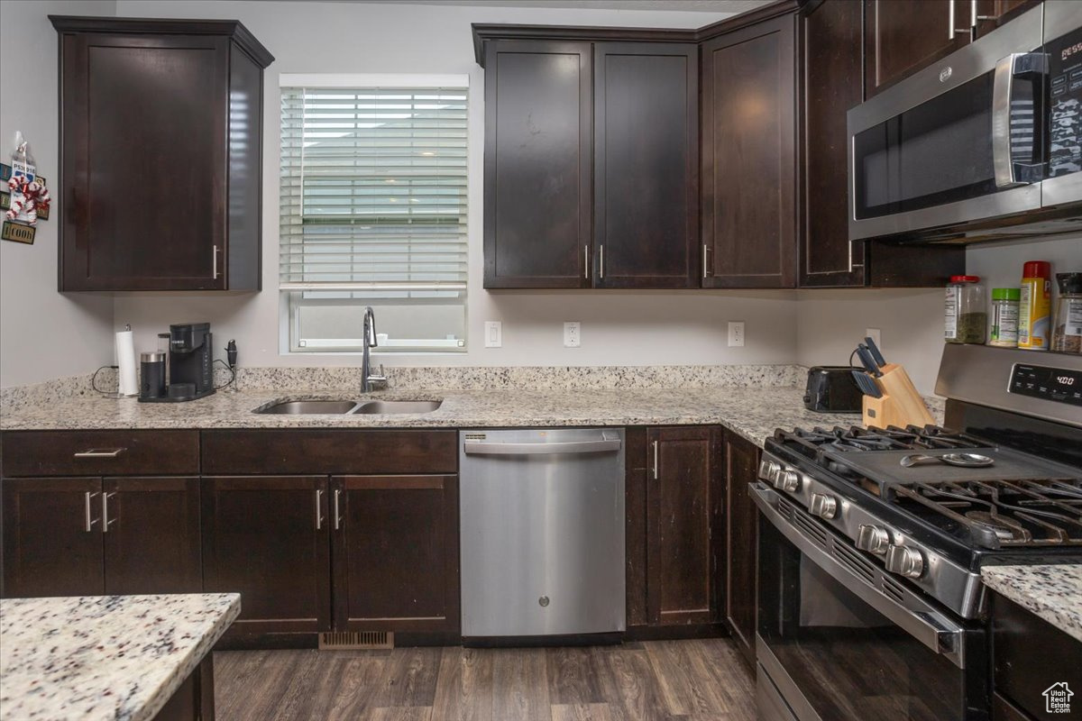 Kitchen with dark wood-type flooring, stainless steel appliances, a healthy amount of sunlight, and sink