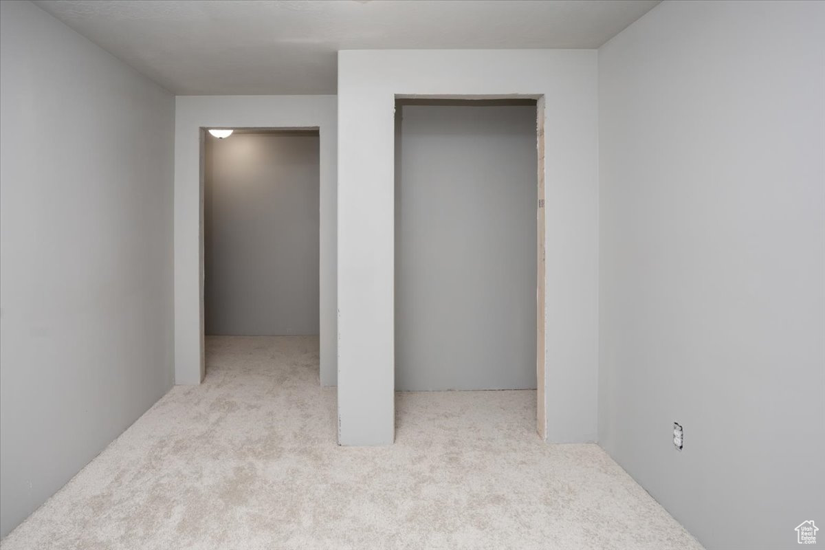 Unfurnished bedroom featuring light colored carpet and a closet