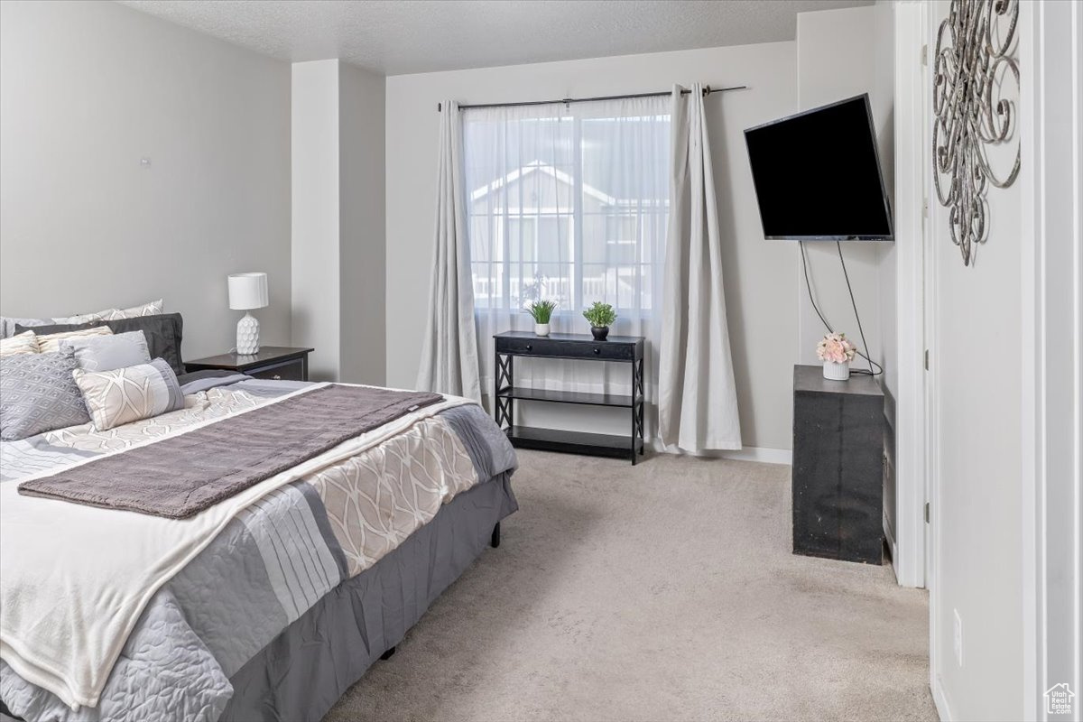 Carpeted bedroom with a textured ceiling