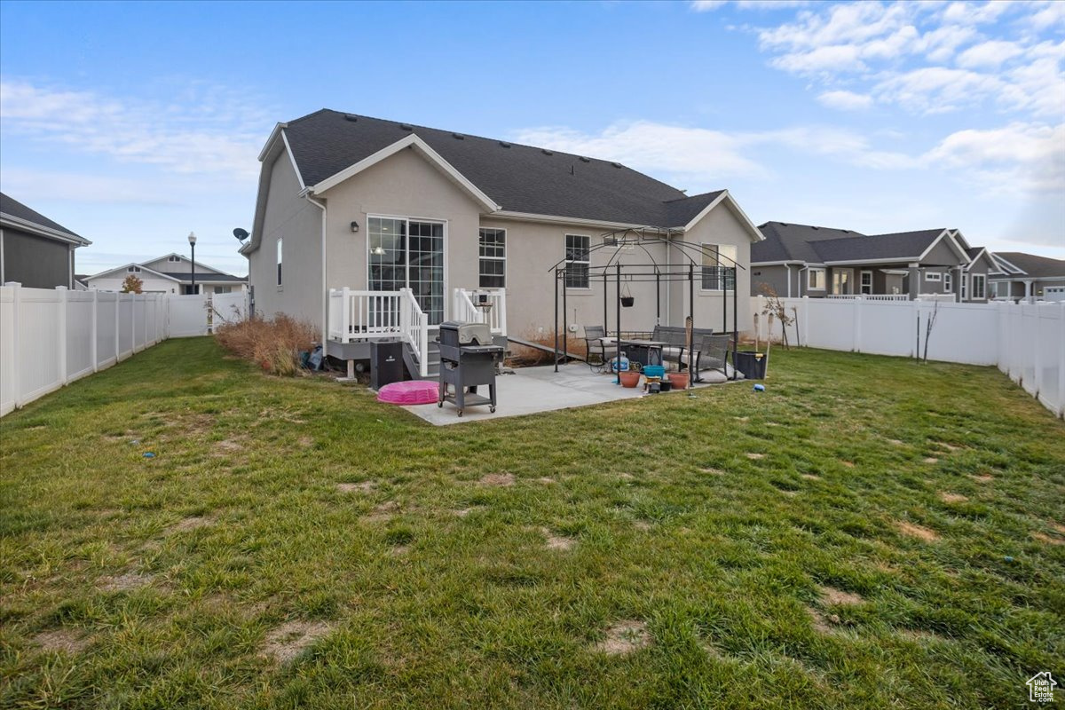 Rear view of property featuring a patio area and a yard