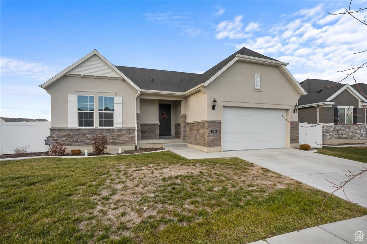 View of front facade featuring a garage and a front yard