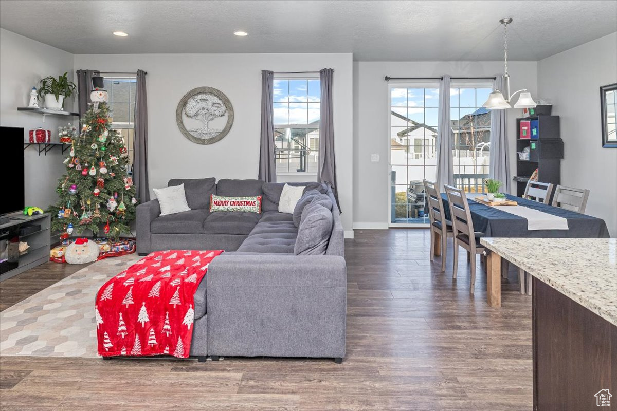 Living room with a notable chandelier and dark hardwood / wood-style floors