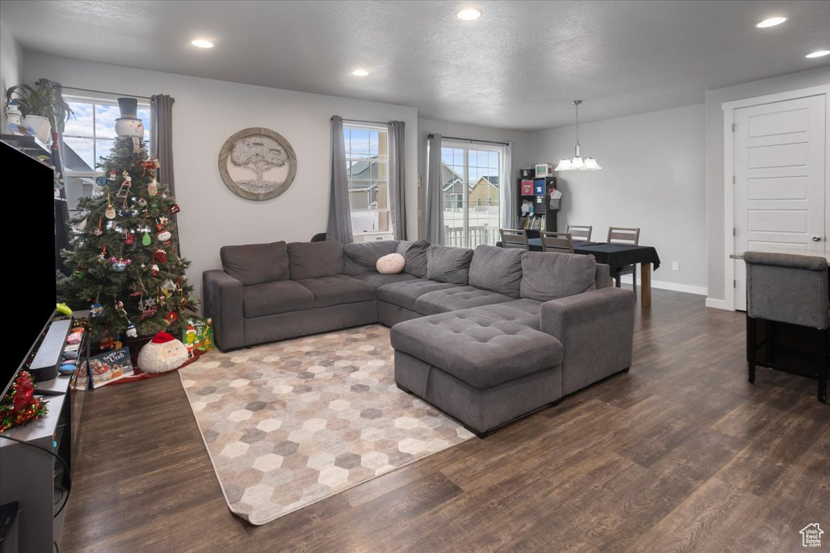 Living room with a notable chandelier, dark hardwood / wood-style flooring, and a textured ceiling