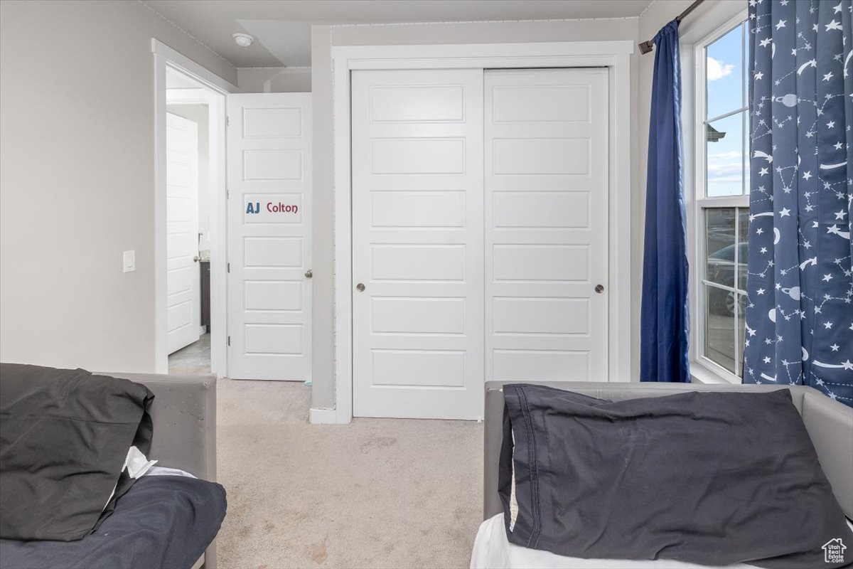 Bedroom featuring carpet flooring and a closet