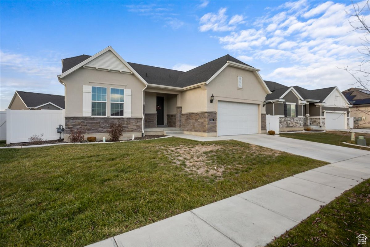 View of front facade featuring a front yard and a garage