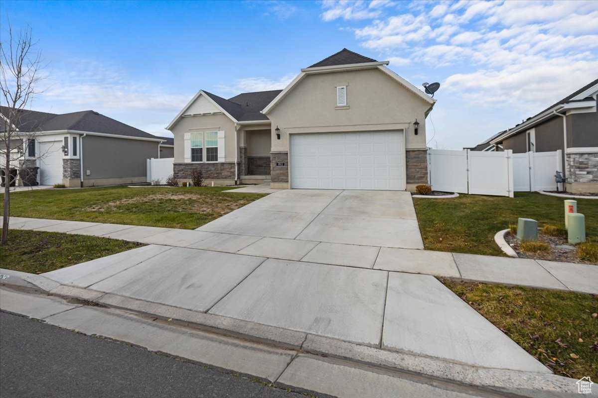 View of front facade featuring a front lawn and a garage