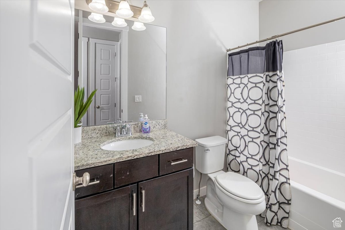 Full bathroom featuring tile patterned floors, shower / bath combo, toilet, and vanity