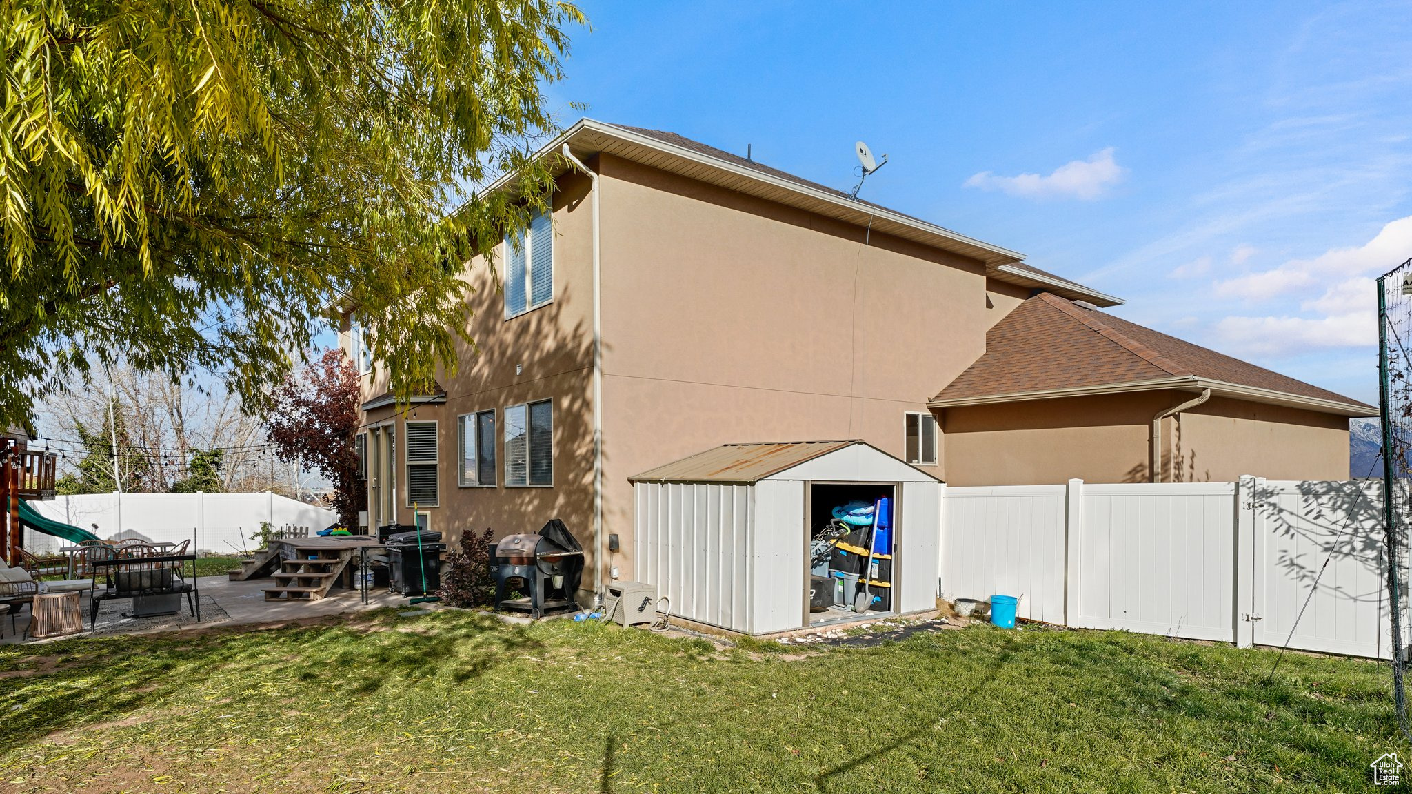 Rear view of house with a patio area, a shed, and a yard