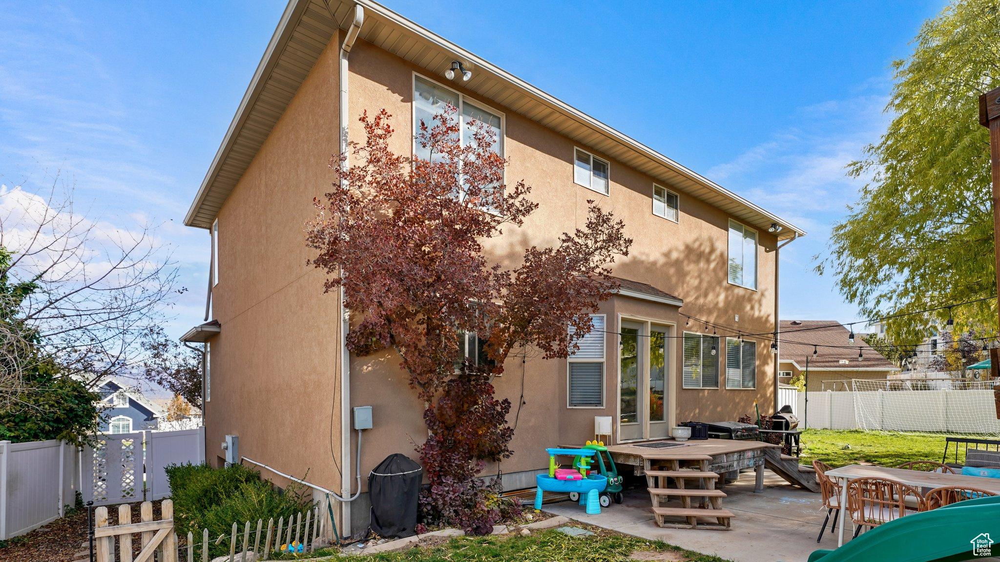 Back of house with a deck and a patio area