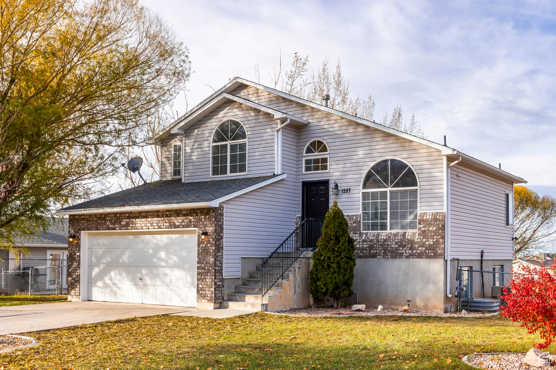 View of front of house with a garage and a front lawn