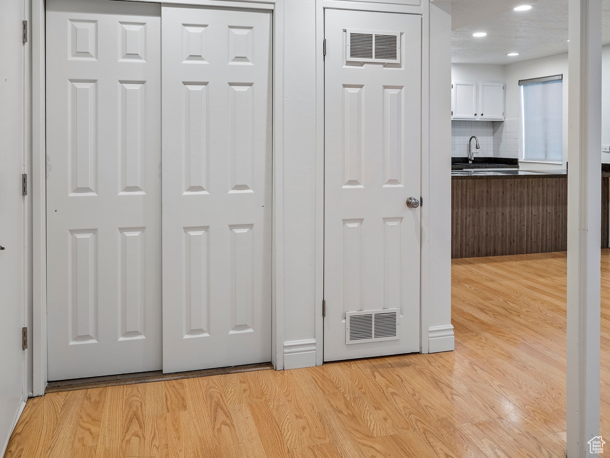 Room details featuring decorative backsplash, sink, and hardwood / wood-style flooring