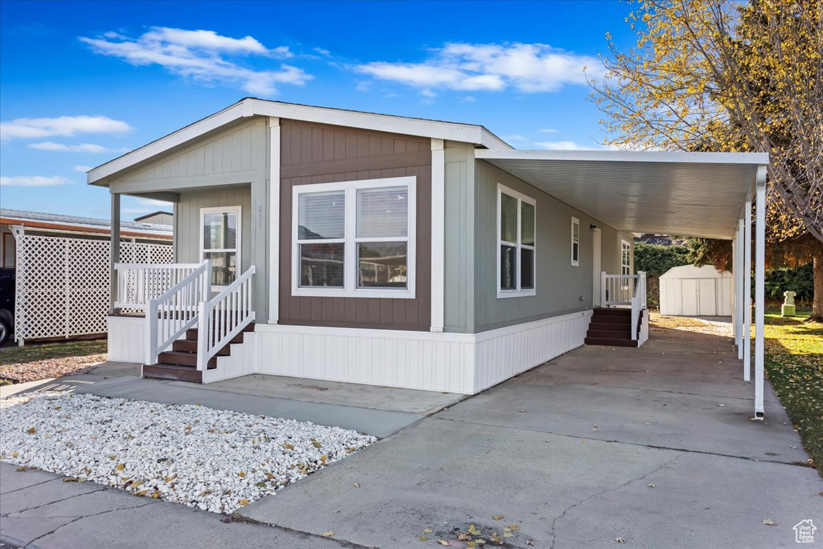 View of front facade with a storage unit and a carport