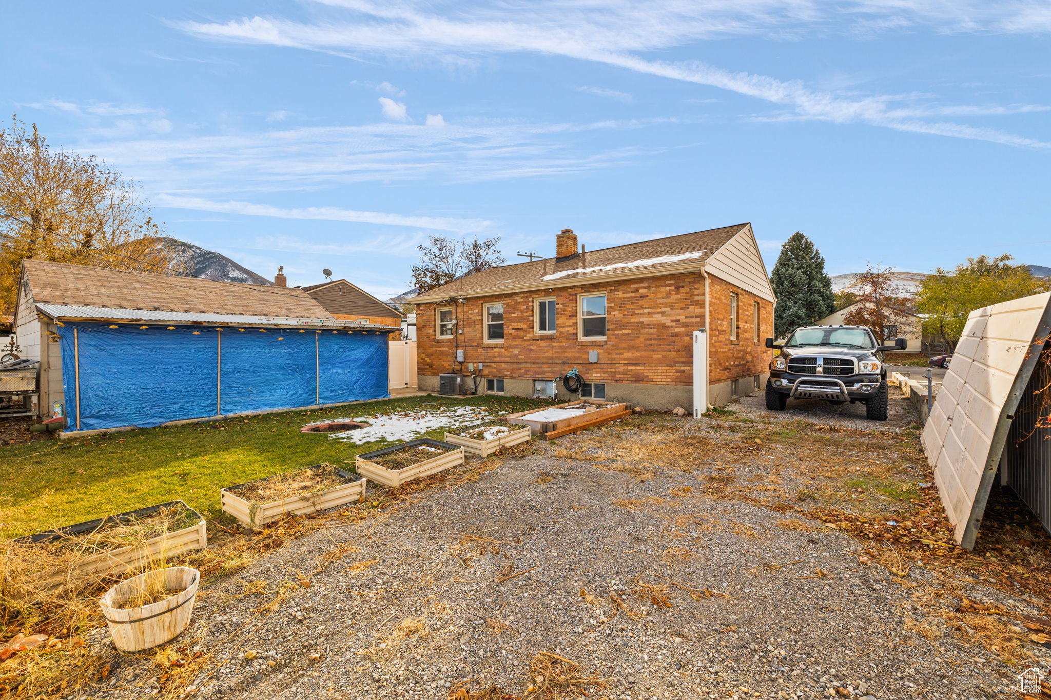 Rear view of property with a mountain view and a lawn
