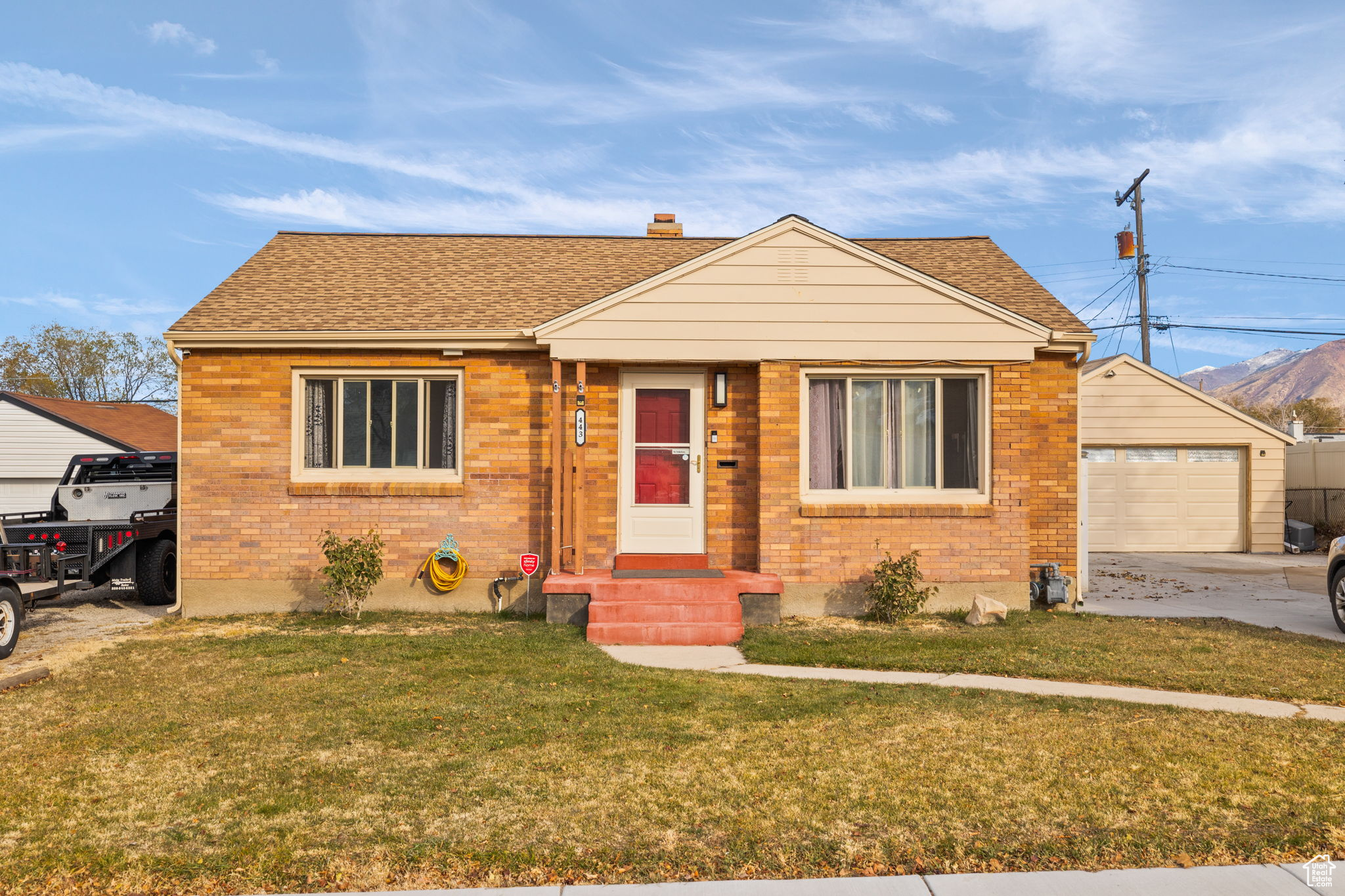 Bungalow-style home with a garage, an outdoor structure, and a front yard