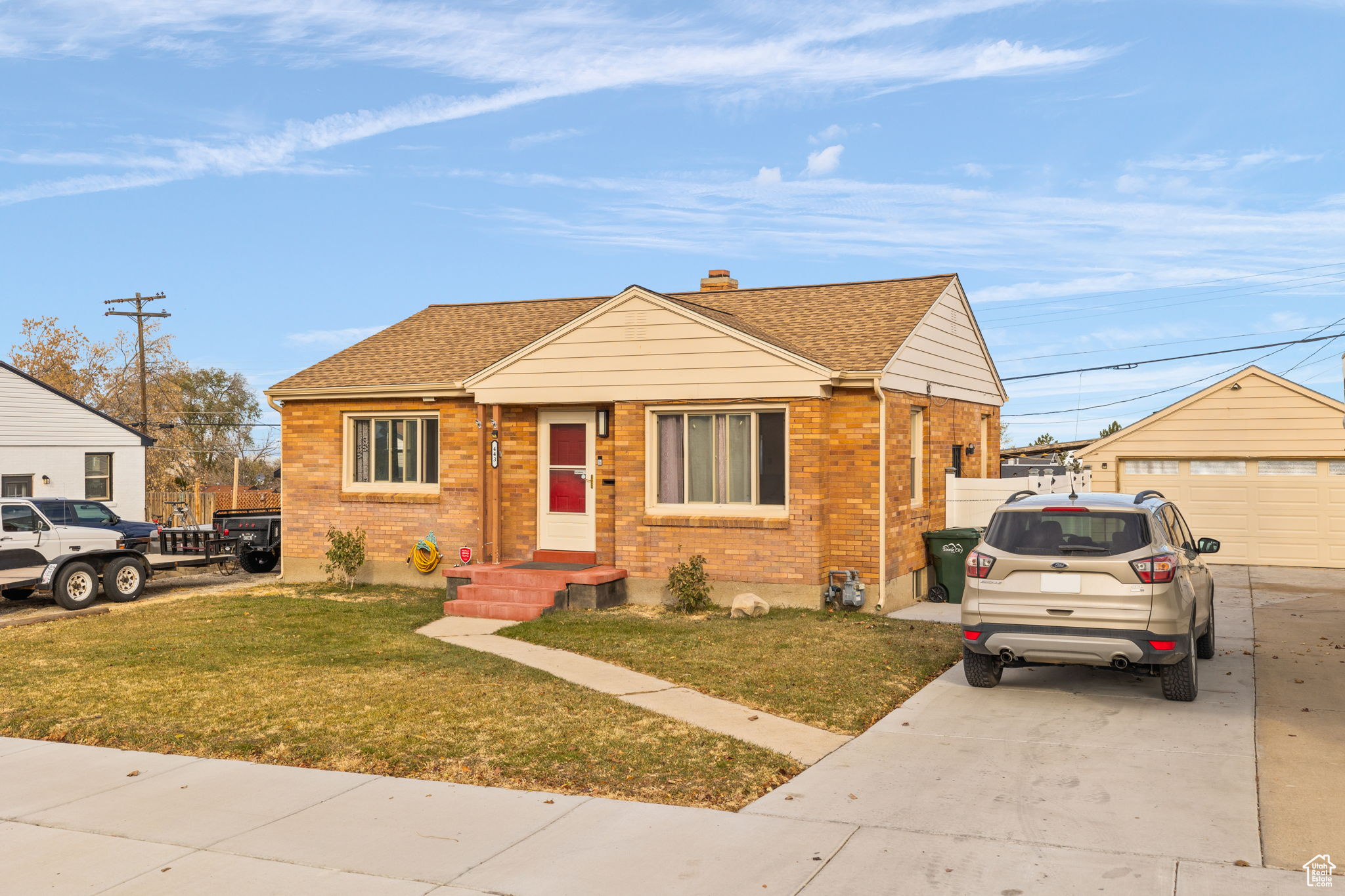 Bungalow with an outbuilding, a front lawn, and a garage