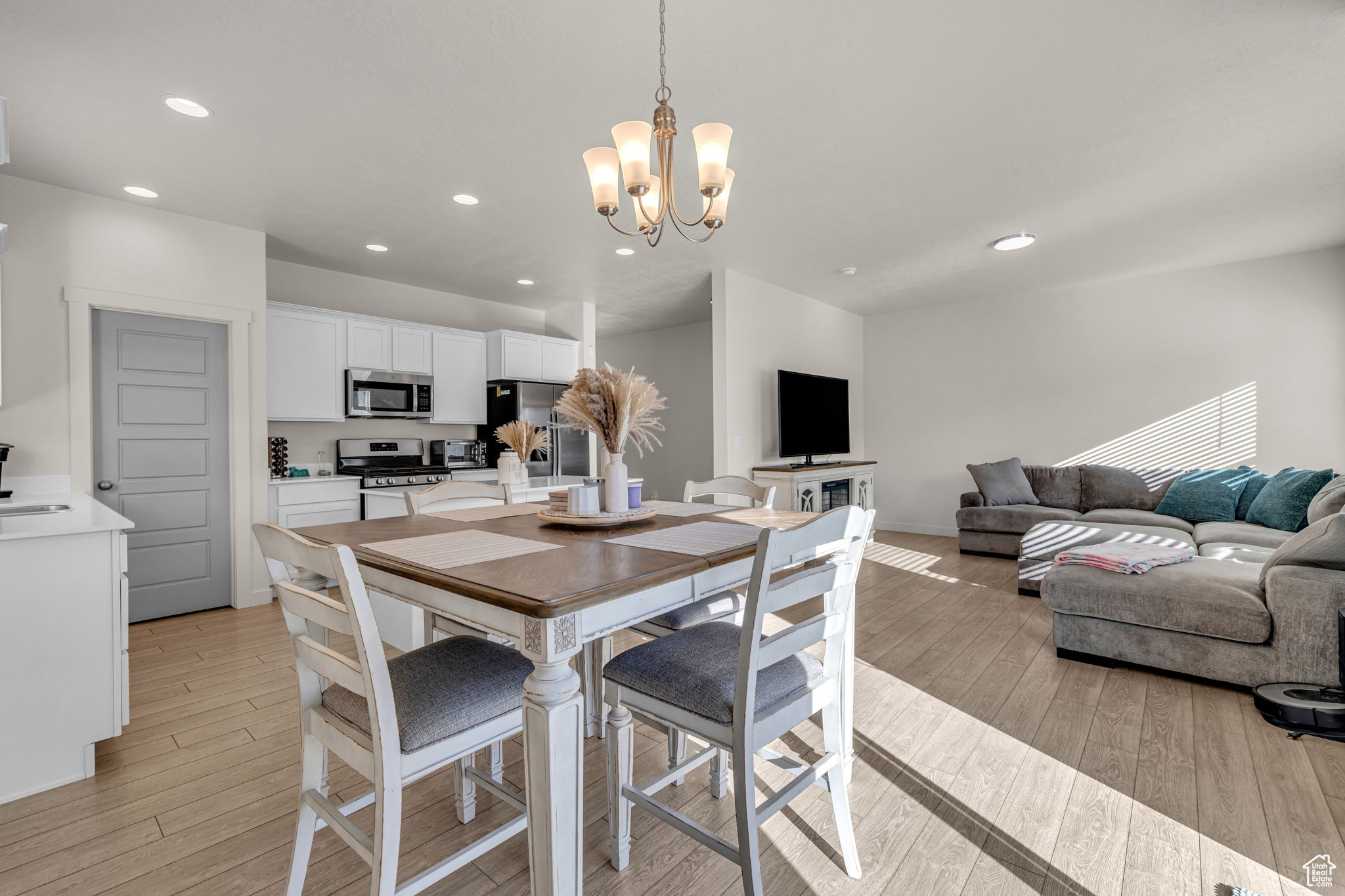 Dining space with an inviting chandelier and light hardwood / wood-style flooring