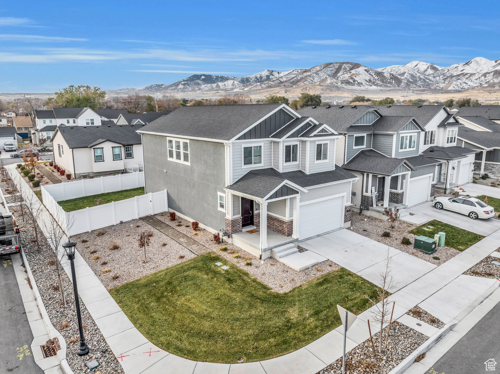 Exterior space with a mountain view, a front lawn, and a garage