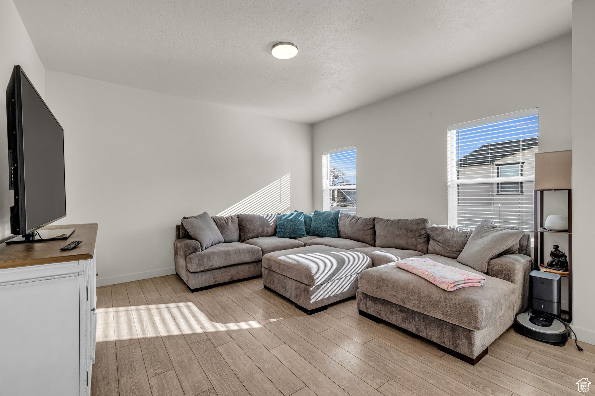 Living room with light wood-type flooring and a textured ceiling